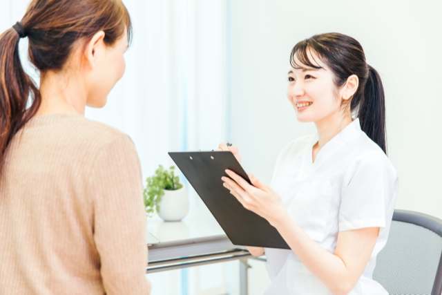看護師から問診を受ける女性