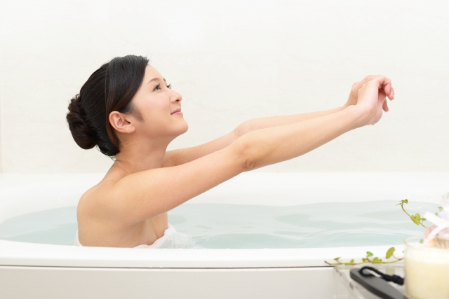 お風呂で体を伸ばす女性